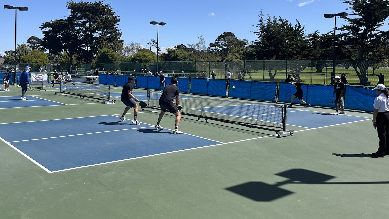 4 players playing on a pickleball portable net